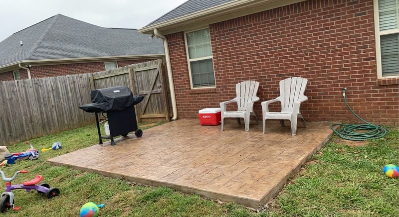 Residential concrete patio with outdoor furniture and grill in Spartanburg SC backyard